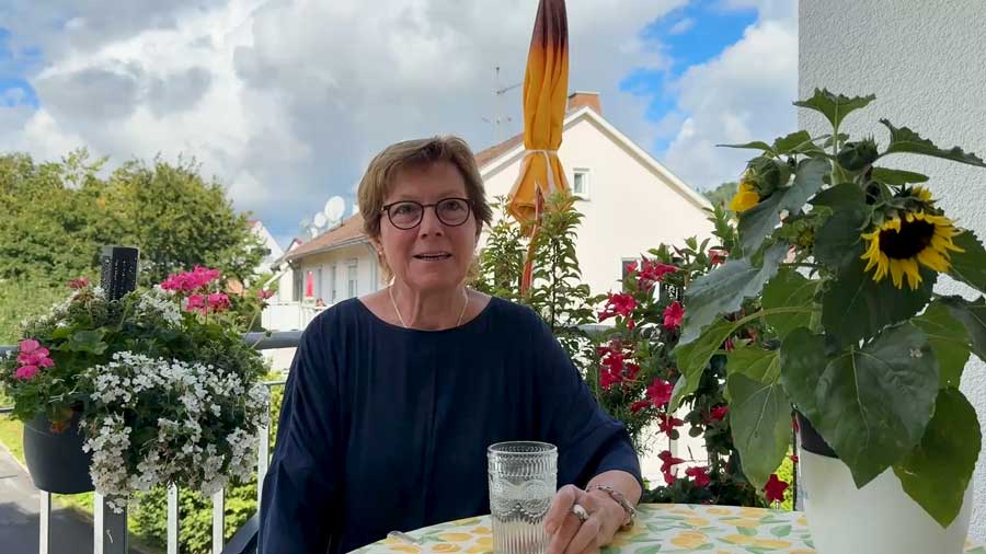 Von Blumen umgeben berichtet Karin auf ihrem Balkon von ihrem neuen Leben in ihrer schönen barrierefreien Wohnung.
