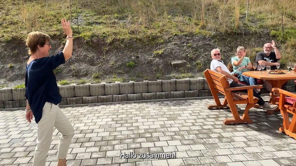 Rentnerin Karin läuft zu einem Tisch, wo ihre Freunde sie begrüßen.