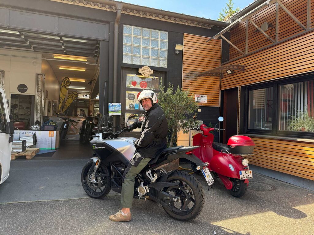 Michael Krause sitzt auf seinem E-Motorrad und lächelt in die Kamera.