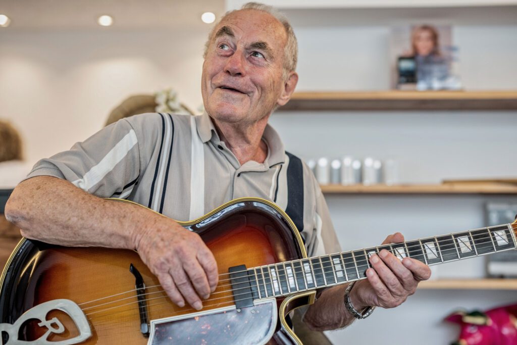 Manfred Bertz genießt den Klang seiner Gitarre dank gut eingestelltem Hörgerät.