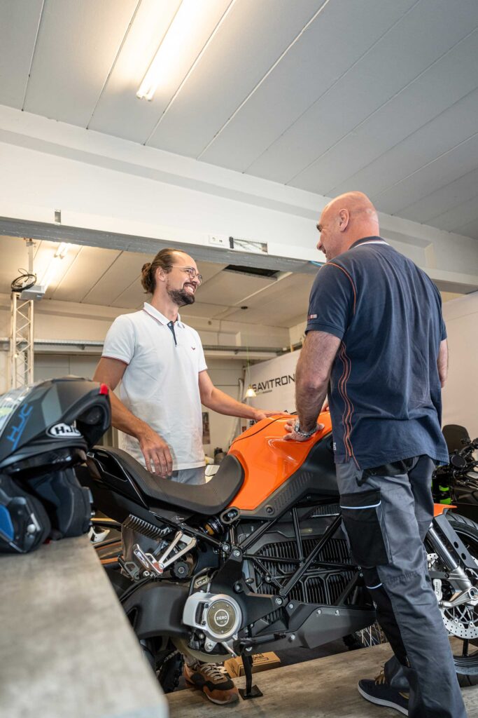 Savitron-Chef zeigt Kunde Michael ein leistungsstarkes Elektro-Motorrad