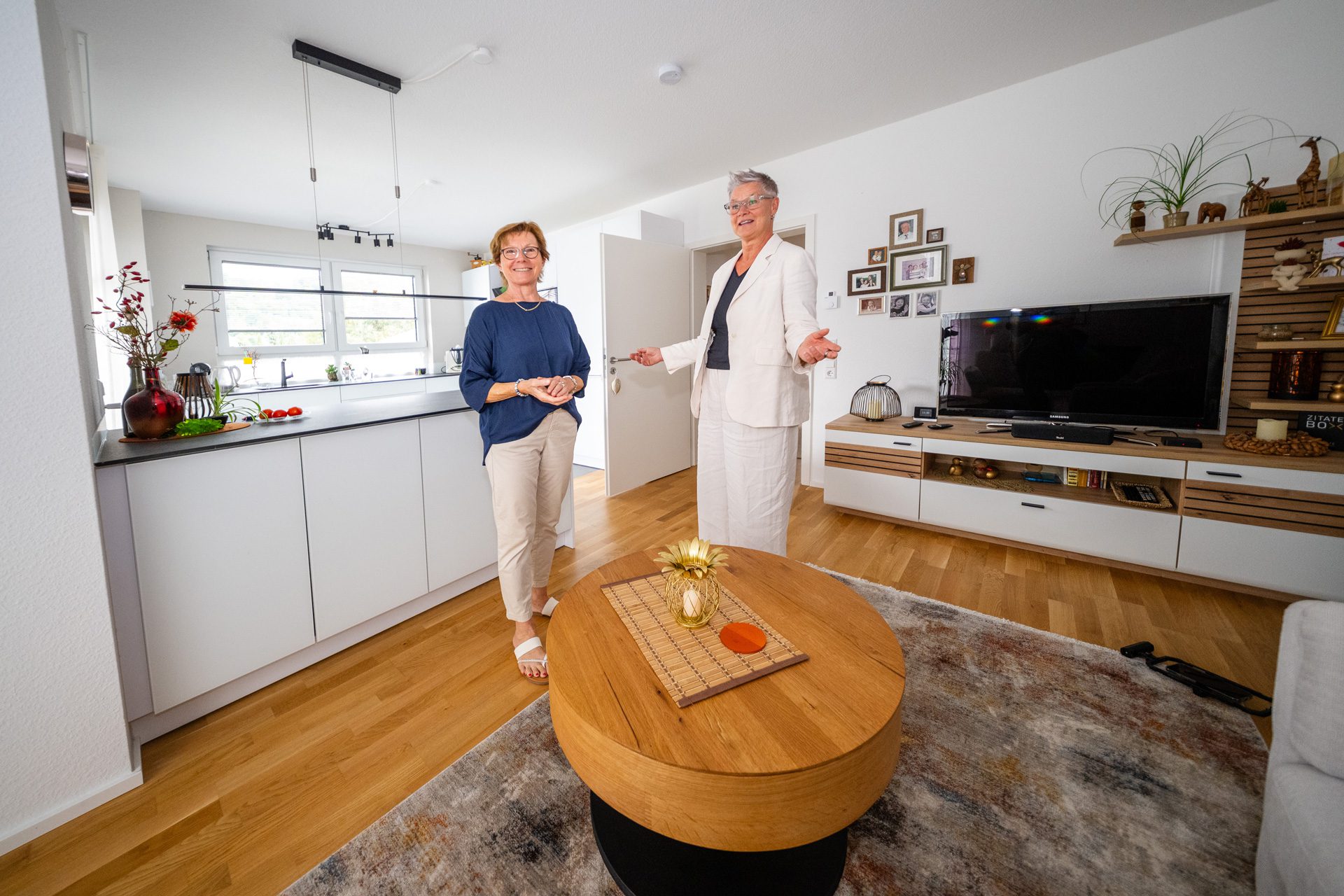 Maklerin Anke Grabl und Karin stehen im hellen Wohnzimmer der neuen Wohnung.
