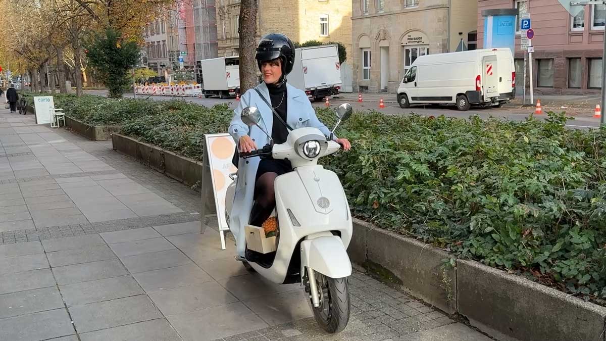 Tini fährt nach dem Einkaufen mit ihrem E-Roller davon