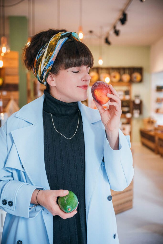 Tini atmet den Duft reif geernteter Früchte ein.