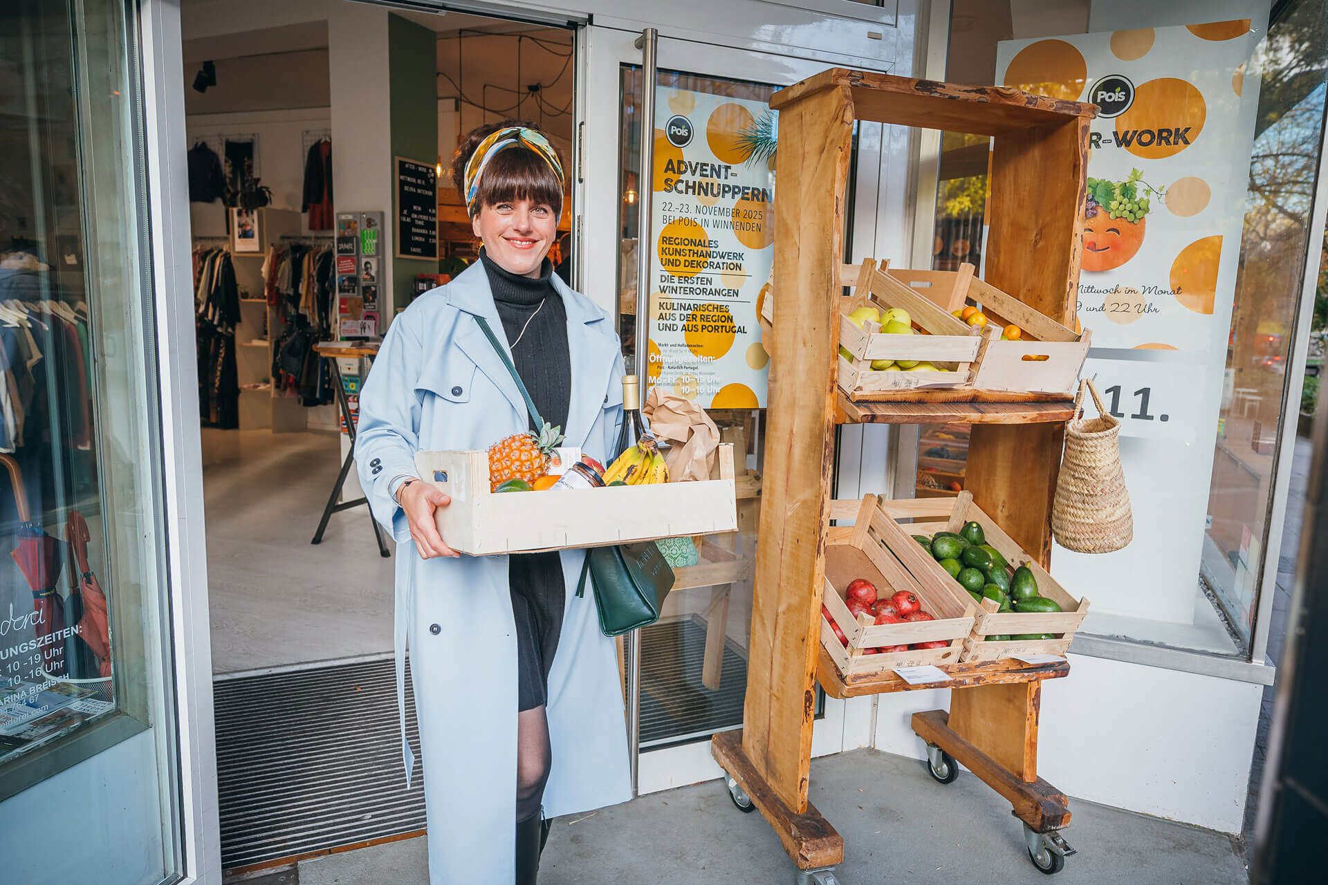 Tini kommt mit einer vollen Kiste mit Einkäufen aus dem Obst- und Gemüseladen.