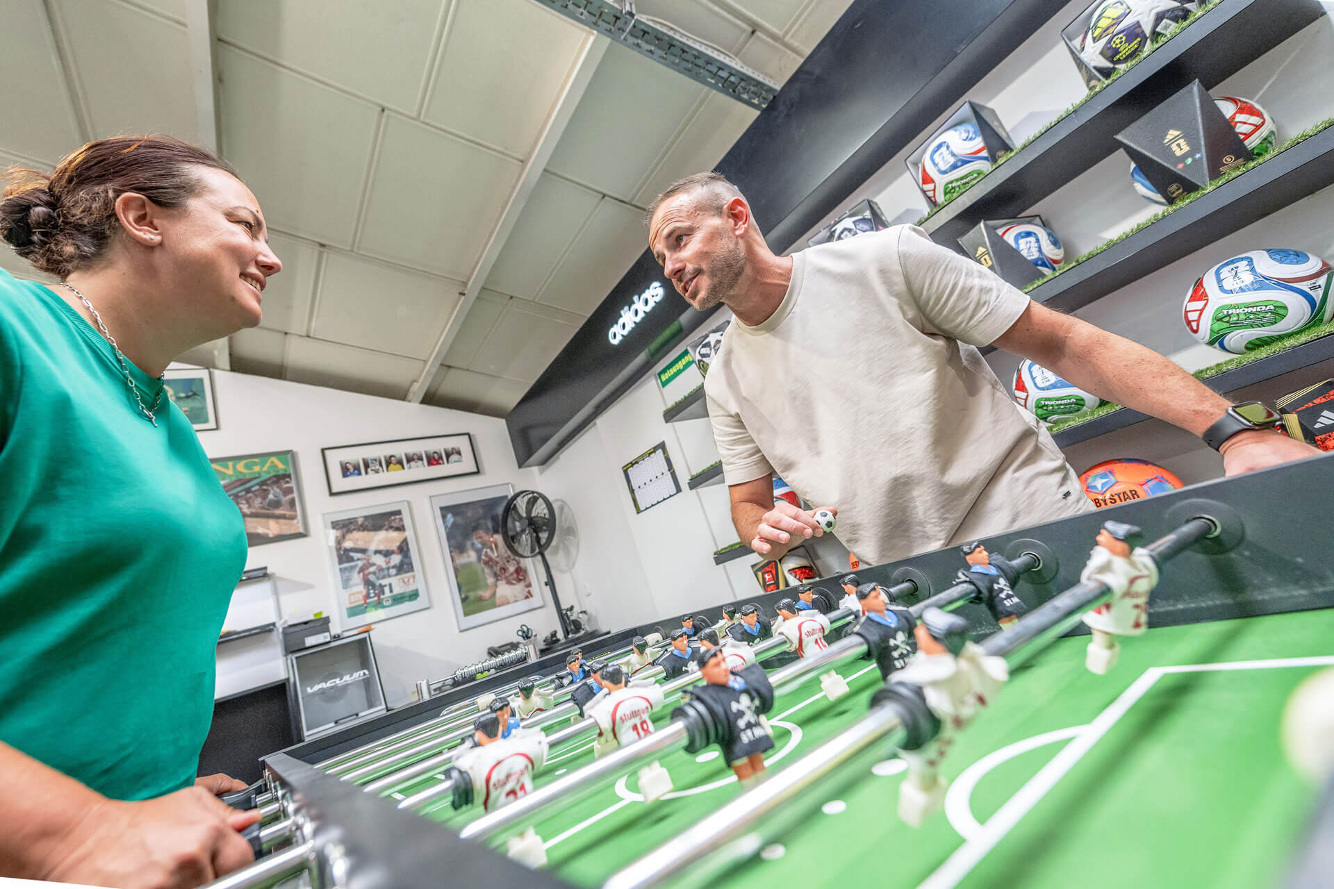 Geschäftsführerin des Sportgeschäfts Sport Schwab Melanie Schwab und Zoran Čutura spielen Tischkicker