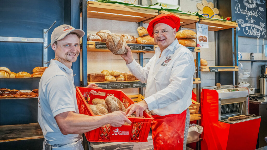 Julian und Hermann Schöllkopf legen frisch gebackene Sauerteig-Brote in die Auslage im Laden.