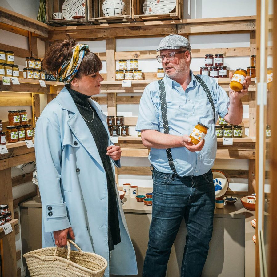 Matthias zeigt Tini selbst produzierte Produkte und Geschenkartikel.